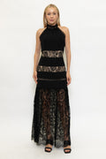 Model wearing a black halter maxi dress with lace paneling and a flowing lace skirt