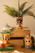 Close-up of orange dress fruit crown lady planter with sunglasses and tropical plant