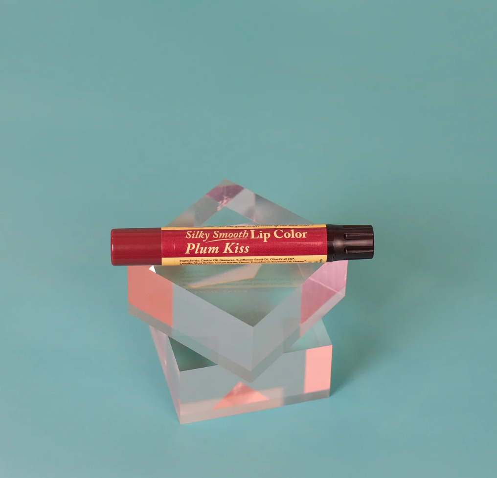 The Naked Bee Plum Kiss Silky Smooth Lip Color on teal background