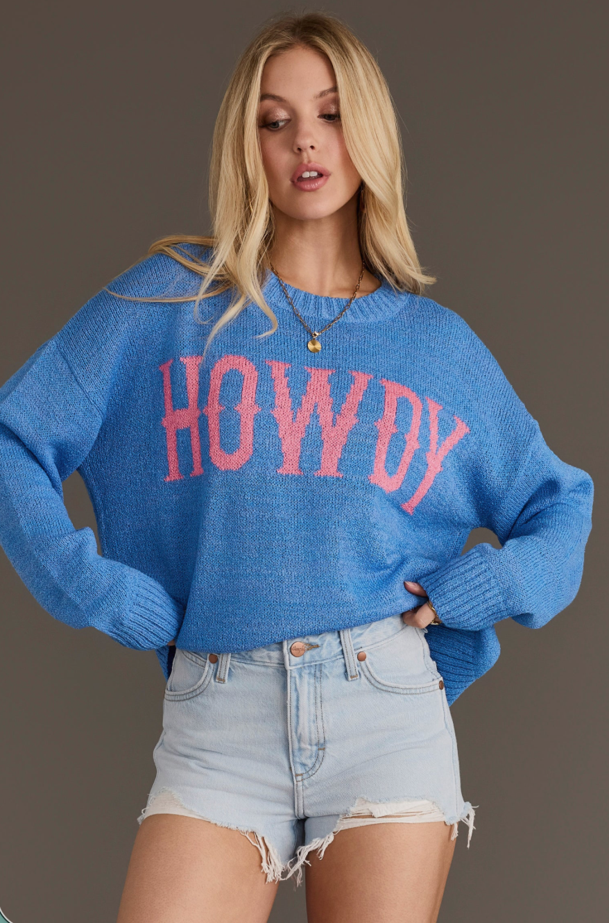 Model wearing a blue Howdy lightweight sweater, angled front view