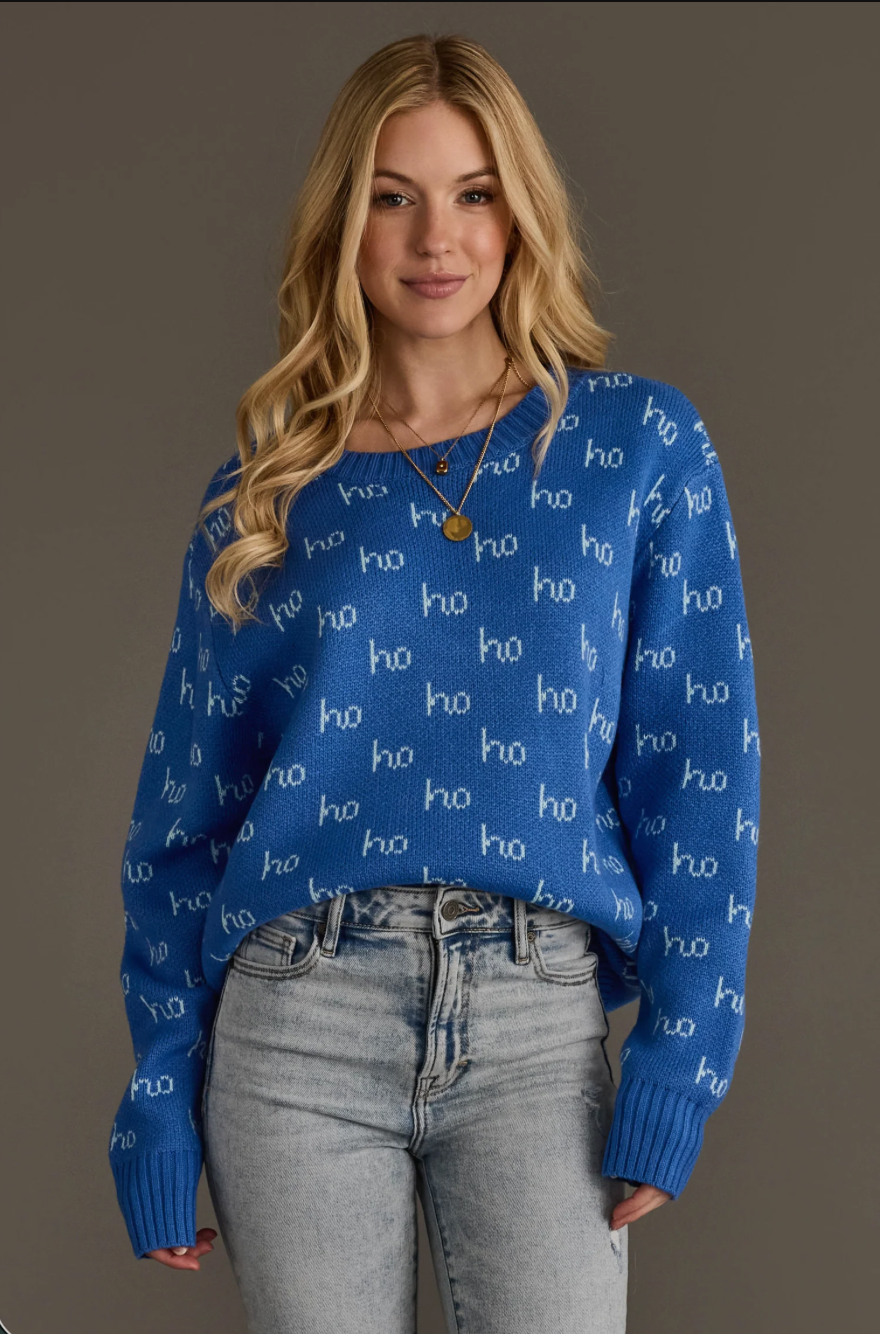 Model wearing a blue ho ho ho pattern sweater with jeans, full body view